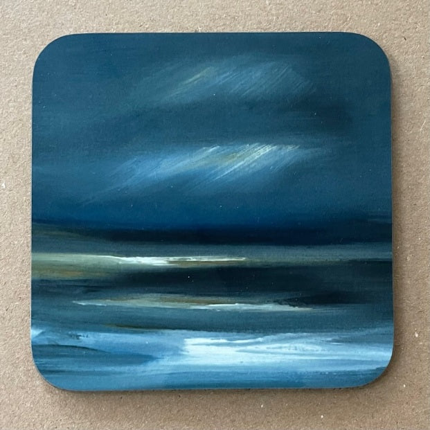 Coaster showing a Scottish seascape with a rocky beach in the foreground.