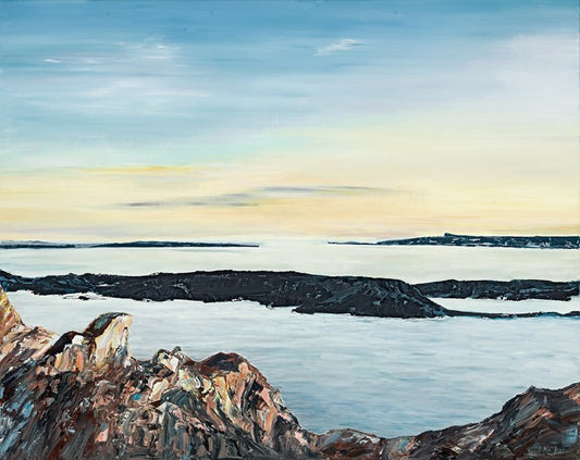 Scottish scene with pale light blue and yellow sky with rocks and sea in the foreground.