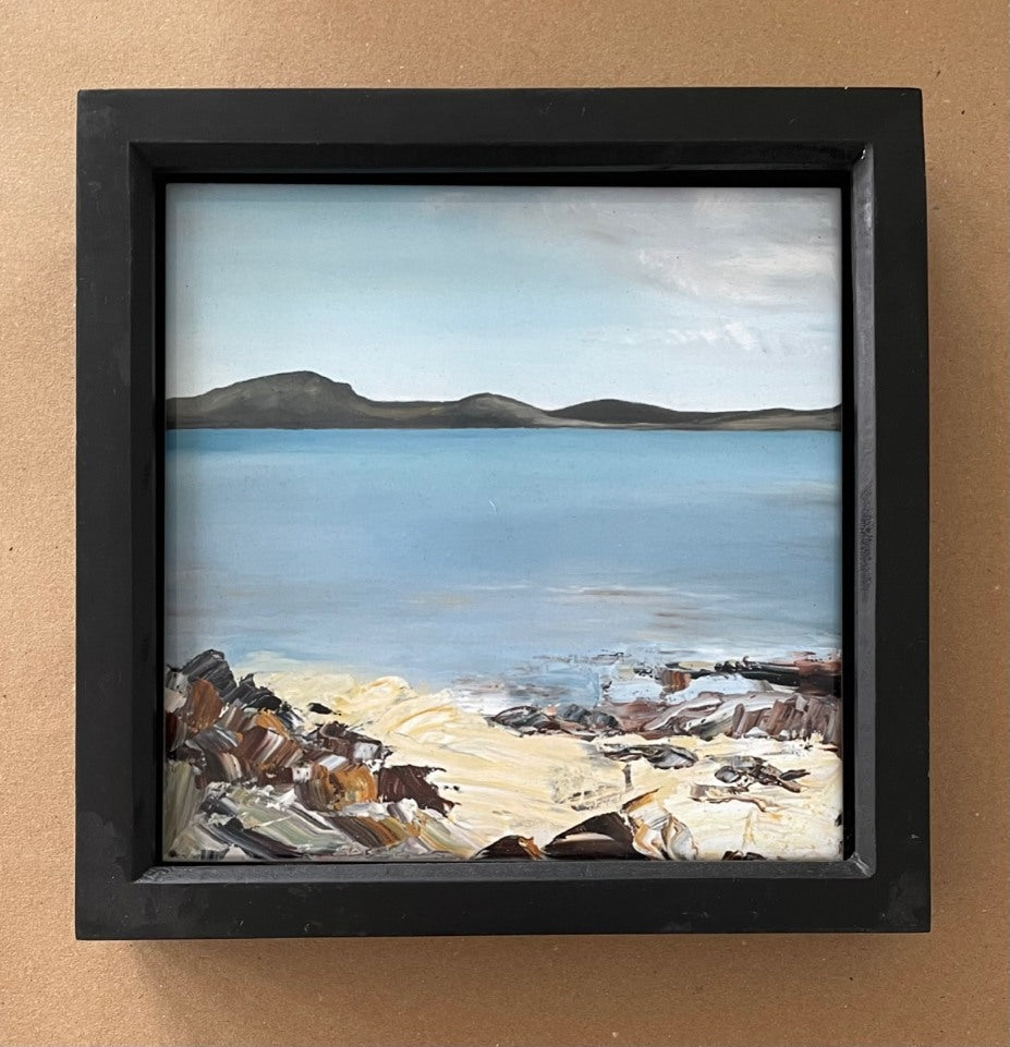 Scottish seascape with beach in foreground and grey hills beyond.
